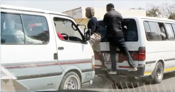  ??  ?? Touts block a commuter omnibus from loading passengers at an illegal pick-up point along 6th Avenue in Bulawayo, recently