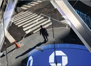  ?? Bloomberg photo by Michael Nagle ?? A person is reflected in the window of a JPMorgan Chase bank branch across the street from the company’s headquarte­rs in New York on Sept. 21, 2020.