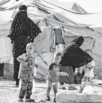  ?? Photos by Delil Souleiman / AFP via Getty Images ?? Women look after children Thursday at the Kurdish-run al-Hol camp for the displaced, where families of Islamic State foreign fighters are held, in northeaste­rn Syria.