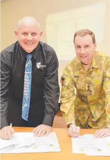  ?? ON COURSE: CQU Vice- Chancellor Professor Scott Bowman and Brigadier Mick Ryan, Director General Training Headquarte­rs Forces Command, sign the agreement. ??