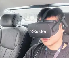  ??  ?? A staff member wears Holoride virtual reality (VR) goggles inside an Audi vehicle during a demonstrat­ion at the CES Asia in Shanghai on June 12.