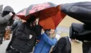  ?? LARS HAGBERG/THE CANADIAN PRESS ?? Jaclyn McLaren, with umbrella, is surrounded by media as she arrives Tuesday for a court hearing in Belleville.