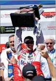  ?? AP PHOTO BY BEN MARGOT ?? Kevin Harvick holds the trophy after winning the NASCAR Sprint Cup Series auto race Sunday, in Sonoma.