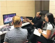  ?? TIM REYNOLDS / THE ASSOCIATED PRESS ?? NBA referee Eric Lewis, centre, breaks down a play with referees-in-training Ashley Gilpin, left, and Natalie Sago.