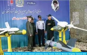  ?? — AFP ?? TEHRAN: This handout picture released yesterday shows Iranian Defense Minister Brigadier General Amir Hatami (center left) standing by the missiles “Balaban” (left), “Ghaem” (bottom) and “Yasin” (right) during an unveiling ceremony.