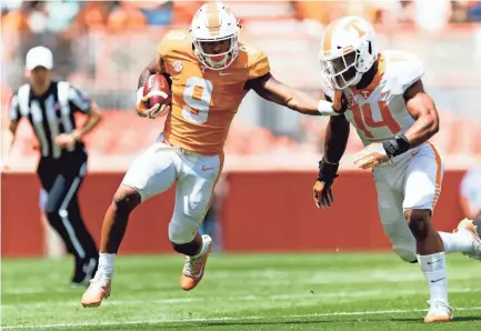  ??  ?? Tennessee running back Tim Jordan (9) runs down the field while pushing away Tennessee linebacker Quart'e Sapp (14) during the Tennessee Volunteers Orange & White spring game at Neyland Stadium in Knoxville, Tennessee on Saturday, April 21, 2018....