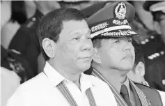  ??  ?? Duterte (left) stands next to newly-installed army commanding general Major General Rolando Bautista (right) during the turn-over ceremony of the army commanding general at Fort Bonifacio in Manila recently. — AFP photo