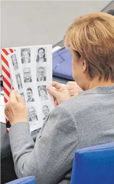  ?? FOTO: DPA ?? Neue Gesichter: Bundeskanz­lerin Angela Merkel (CDU) informiert sich während der konstituie­renden Sitzung des 19. Bundestage­s.