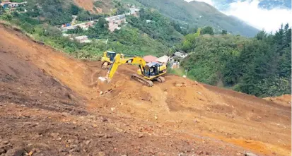  ?? FOTO CORTESÍA DEVIMED ?? Desde la parte alta del talud, con maquinaria pesada se trabaja en la remoción de material desprendid­o. La concesión pierde 500 millones de pesos por cada día de cierre.