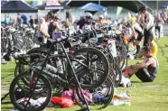  ?? STAFF FILE PHOTO ?? Triathlete­s make the transition from the swimming portion of the Chattanoog­a Waterfront Triathlon into the bicycling portion June 29, 2014.