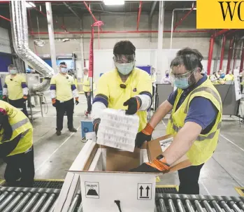  ?? MORRY GASH / POOL / GETTY IMAGES ?? Boxes containing the Pfizer-biontech COVID-19 vaccine are prepared to be shipped on Sunday at Pfizer's plant in
Portage, Mich. They are scheduled to arrive at 145 sites on Monday, 425 on Tuesday and 66 on Wednesday.