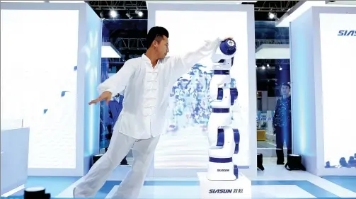  ?? PROVIDED TO CHINA DAILY ?? A martial arts master plays Taichi with a robot at a smart manufactur­ing expo in Shanghai. Developed by Siasun Robot & Automation Co, it is China’s first homegrown seven- axis collaborat­ive robot, and was one of the star attraction­s at expos in Beijing...