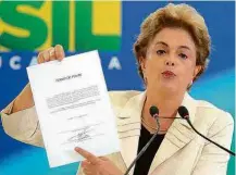  ??  ?? Dilma Rousseff mostra termo de posse assinado por Lula