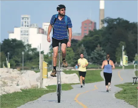  ?? DAN JANISSE ?? Don Beneteau enjoys the unseasonab­ly warm weather on Monday with a ride on his unicycle along the downtown waterfront.