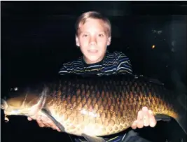  ??  ?? SURPRISE CATCH: William Henderson shows off the 20lb carp he landed in the River Stour at Kingsmead