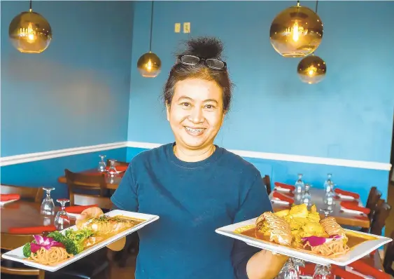  ?? PHOTOS BY APRIL GAMIZ/THE MORNING CALL ?? Co-owner Ngamjit ‘Jass’ Charoenpot­e holds lobster pad pong karee (right) and choo chee salmon inside Thai Origin. The restaurant opened in mid-November in the Tilghman Square shopping center at 4686 Broadway.