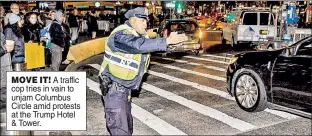  ??  ?? MOVE IT! A traffic cop tries in vain to unjam Columbus Circle amid protests at the Trump Hotel & Tower.