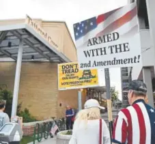  ??  ?? Gun rights advocates peacefully protest near the Tattered Cover book store during Watts’ appearance.