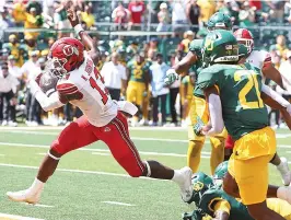  ?? ?? Utah quarterbac­k Nate Johnson (13) scores a touchdown Saturday against Baylor in the second half of an NCAA college football game in Waco, Texas. (AP Photo/jerry Larson)