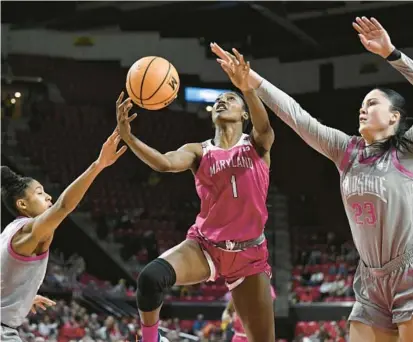  ?? GREG FIUME/GETTY ?? Maryland guard Diamond Miller drives to the basket in the third quarter against Ohio State’s Taylor Thierry, left, and Rebeka Mikulasiko­va on Sunday at Xfinity Center in College Park. Miller had a game-high 29 points plus 10 rebounds and three steals.