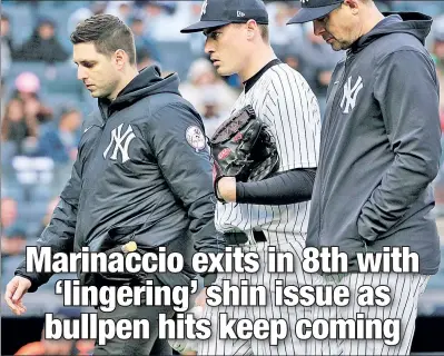  ?? N.Y. Post: Charles Wenzelberg ?? HE’S OUT: Reliever Ron Marinaccio (center) is escorted back to the dugout in the eighth inning by manager Aaron Boone (right) and a trainer after the pitcher experience­d right shin soreness.