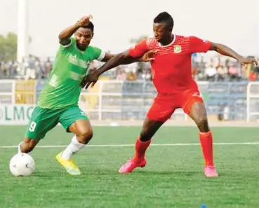  ??  ?? Timothy Danladi (R) vies for the ball with a Nasarawa United striker during their league match at the Lafia township stadium