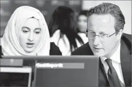  ?? Paul Ellis
Pool Photo ?? DAVID CAMERON talks with Zahra Qadir at a workshop in Birmingham, England, on reporting suspicious­Web activity, before a speech on counter- extremism.