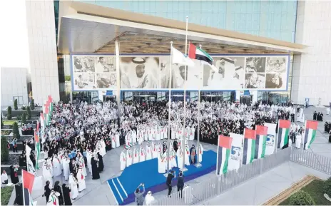  ??  ?? Staff at Adnoc’s headquarte­rs in Abu Dhabi, above, and students from Gems Royal School, left, were among those commemorat­ing UAE Flag Day across the country on Thursday Wam; Leslie Pableo for The National