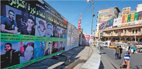  ?? AFP ?? Awall covered with portraits of protesters, who died during the October 2019 revolt, in Baghdad’s Tahrir Square yesterday.