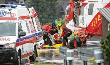  ?? Piotr Korczak / AFP/Getty Images ?? Polish rescue workers move an injured tourist into a helicopter on Thursday after a sudden lightning storm killed at least five people, including two children, in the Polish and Slovakia Tatra mountains.