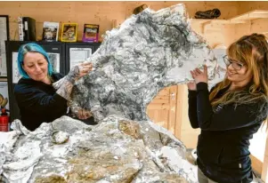  ?? Fotos: Dinosaurie­r-Museum Altmühltal ?? Die beiden Präparator­innen Katrin Nickel (links) und Ronja Sonnensche­in zeigen ein Jacket, in dem die Knochen eines Diplodocus verborgen sind.