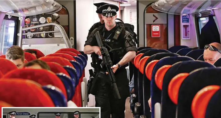  ??  ?? Tickets please: Officers carrying semi-automatic rifles patrol a Virgin train yesterday