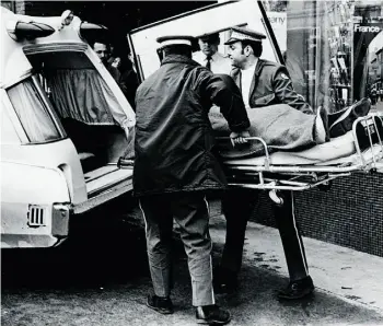  ?? EDMONTON JOURNAL/FILE ?? The body of travel agent Bob Neville is removed after he was shot dead in his office at the Corona Hotel on Jasper Avenue in 1971. Keith Latta, his former business partner and a Queen’s University law professor, was convicted of the murder.