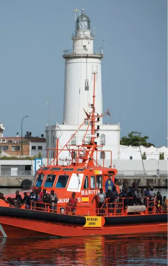  ??  ?? In porto L’arrivo a Malaga di 56 migranti sotto il controllo della Guardia costiera spagnola (Afp)