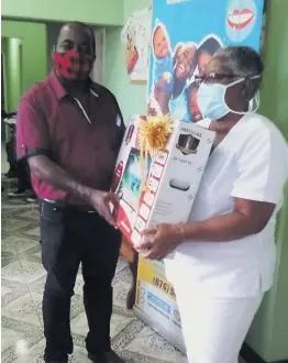  ??  ?? Councillor for the Sligoville division Dwight Burke (left) donates a flatscreen TV to the Sligoville Health Centre in St Catherine.