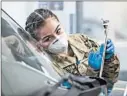  ??  ?? Army Pfc. Sabine Gonzalez helps operate the state’s first coronaviru­s testing center, for first responders, in March. She later lost her grandmothe­r to COVID-19.