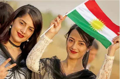  ?? AFP ?? Girls hold a Kurdish flag and flash the sign of victory as they take part in a gathering to urge people to vote in the upcoming independen­ce referendum in the town of Bahirka, north of Arbil, on Friday. —