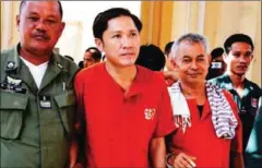  ?? HENG CHIVOAN ?? Ny Sokha (centre left) and Yi Soksan (centre right), are escorted to a hearing at the Appeal Court in Phnom Penh last year.