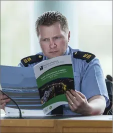  ??  ?? Garda Dave McDonagh reads the plan. Pic: Donal Hackett.