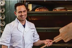  ?? ?? Bäckermeis­ter Roberto Rodriguez holt die Ihle Bio-Brote aus dem großen Steinbacko­fen.