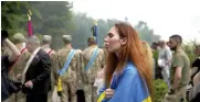  ?? ?? A woman wrapped in a Ukrainian flag attends the funeral of activist and soldier Roman Ratushnyi in Kyiv