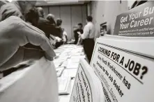  ?? David McNew / Tribune News Service ?? Job seekers look over openings at the WorkSource exhibit May 14 at the Greater Los Angeles Career Expo.