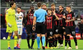  ?? Photograph: Giuseppe Cottini/AC Milan/Getty Images ?? Milan players surround the referee, Daniel Sieber, after he sent off Fikayo Tomori in the Champions League game against Chelsea.