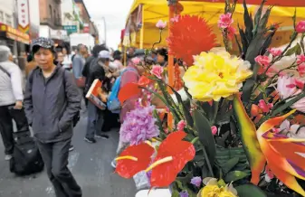  ??  ?? Fairgoers select plants and bouquets at the Chinese New Year Flower Market Fair. The plants symbolize growth, and blooms on New Year’s Day indicate a year of prosperity. Celebrants visit booths at the Flower Market Fair offering bouquets, various...