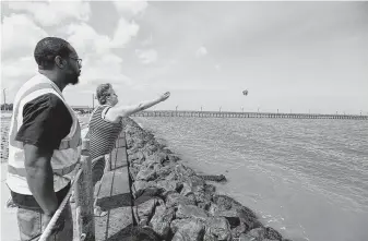  ?? Steve Gonzales / Staff photograph­er ?? Patrick January and his girlfriend, Tasha Price, throw three flowers into the water near where they saw four siblings get swept away by a strong wave at Sylvan Beach Park on Thursday night.