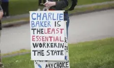  ??  ?? SIGN OF TIMES: A protester displays a sign outside Gov. Charlie Baker’s home on Saturday.