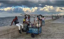  ?? — AFP photo by Yamil Lage ?? A man sells drinks at the Malecon in Havana.