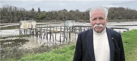  ?? | PHOTO : OUEST-FRANCE ?? Le président de l’associatio­n des copines et des copains des carrelets de la Rance, Jean-François Rimasson, devant deux cabanes sur pilotis encore debout du côté de La Vicomté-sur-Rance (Côtes-d’Armor).