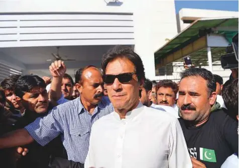  ?? AFP ?? Opposition leader and head of the Pakistan Tehreek-e-Insaf political party Imran Khan leaves Parliament after attending a session in Islamabad. His success in drawing turncoats has fuelled long-standing allegation­s that he’s a pawn for the military.
