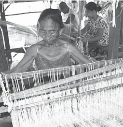  ??  ?? WEAVING FOR A LIVING — A woman in Barangay Barraca, Bangar, La union weaves an ‘Abel Iloko’ using traditiona­l wooden equipment on Friday. The industry has brought better lives to locals with some able to send their children to college. (Erwin G. Beleo)